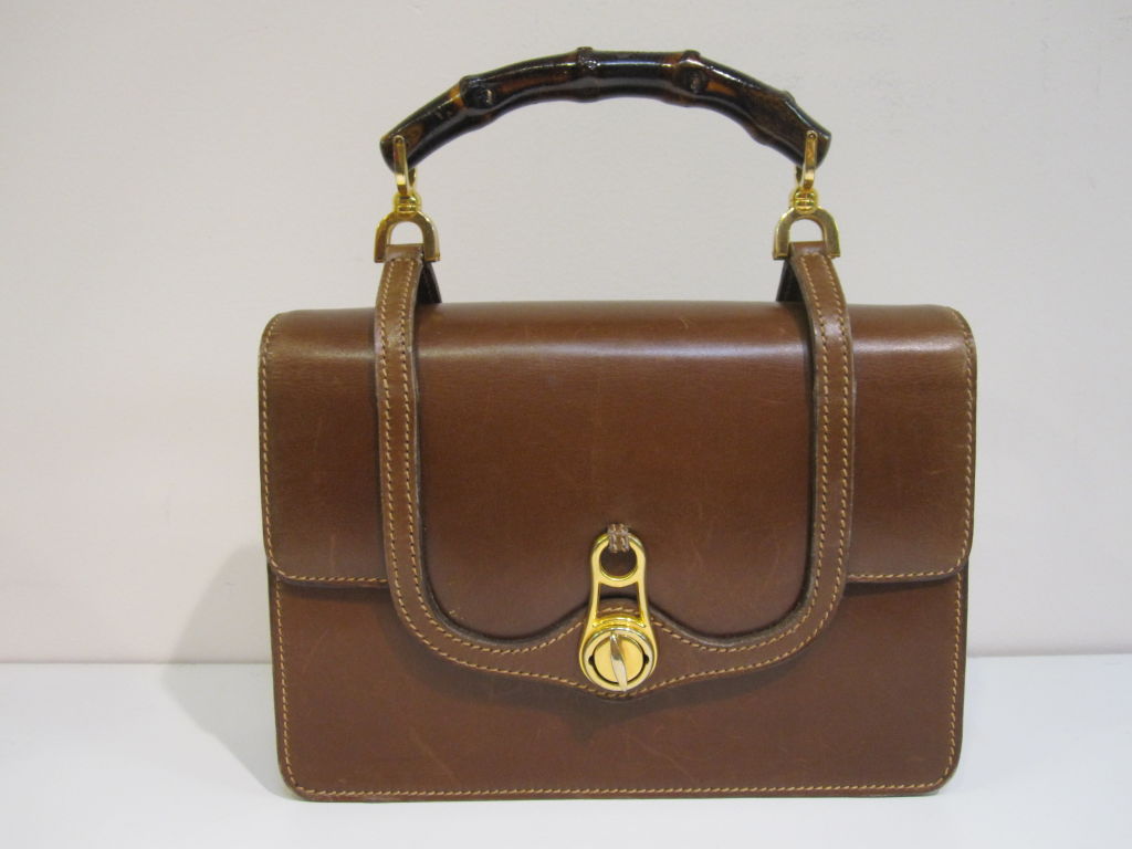 A fantastic 60s / 70s Gucci brown smooth leather handbag with unusual strap design and genuine bamboo handle.  In Excellent condition and measuring 8.5
