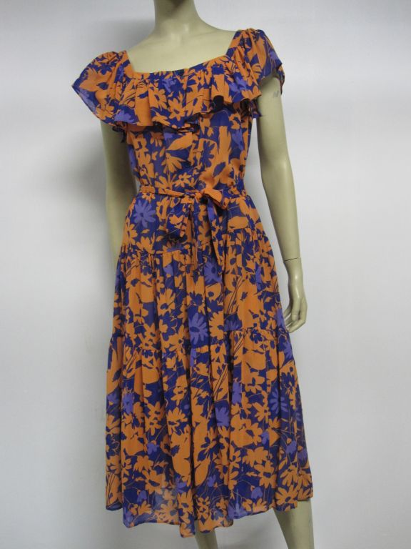 A brightly colored, bold floral print Ted Lapidus crepe dress in orange and purples with a drop-waist, ruffled neckline and waist tie from 