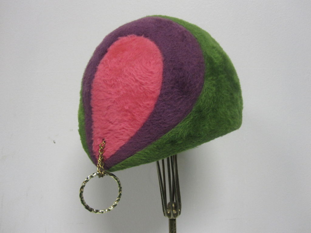 A fantastically hip, mod 60s Adolfo II three color mohair fur felt velour hat in kelly green, royal purple and fuchsia.  An asymmetrical 20s-referenced cloche with its original gold hoop earring still attached.  Fantastic!
