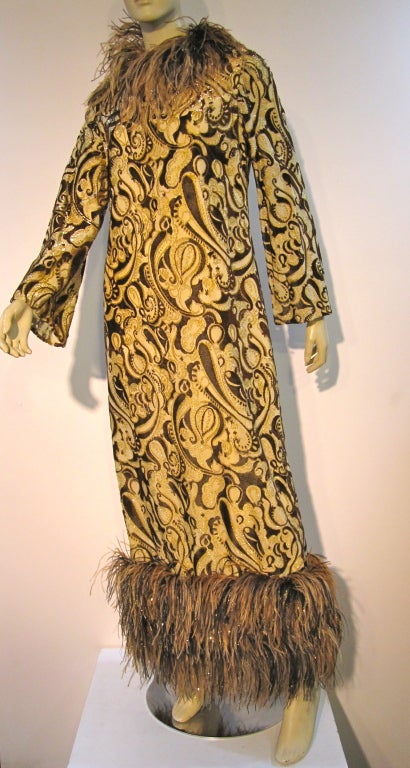 Bill Blass fabulous 60s gown in brown gold and taupe metallic lamé paisley brocade with multicolor ostrich feathers and lurex filament trim at collar, cuffs, and hem.  Size