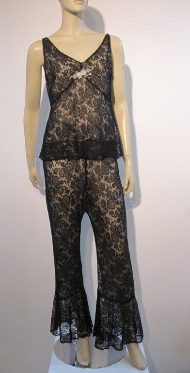 A wonderful 1920s black silk lace pajama set with nude lining, flared legs,  bias cut design and silk flower trim at neckline. Size 4.