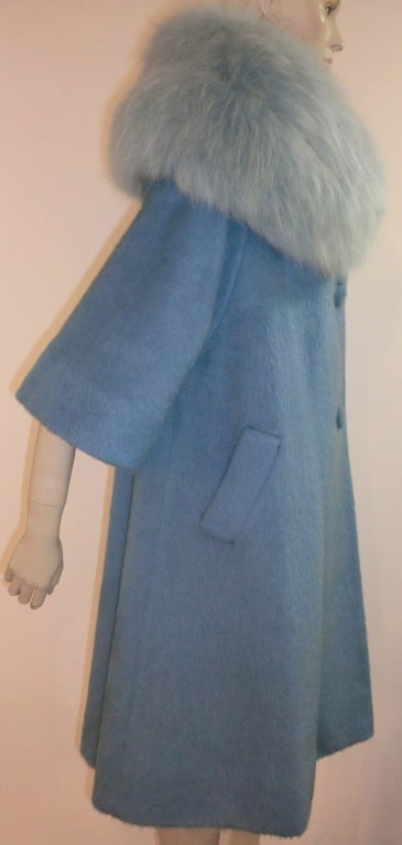 A gorgeous 60s Lilli Ann mohair coat in baby blue with trapeze silhouette, 3/4 sleeves, satin lining, covered buttons and extravagant baby blue dyed fox collar.  Size M.