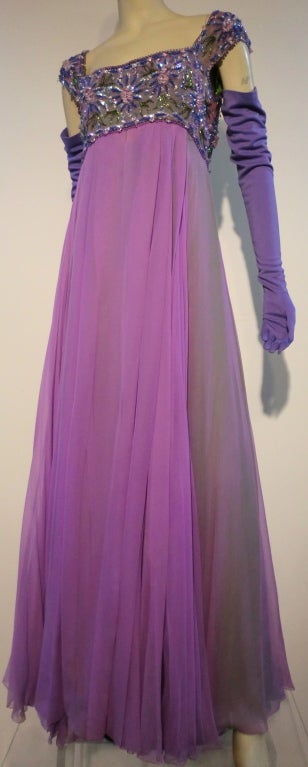 A fantastic 60s Helen Rose evening gown in two vibrant colors of lilac and apple green silk chiffon, one over the other creating lots of depth of color as they move.  The empire bodice is entirely beaded in a floral pattern  with cap sleeves.  Size