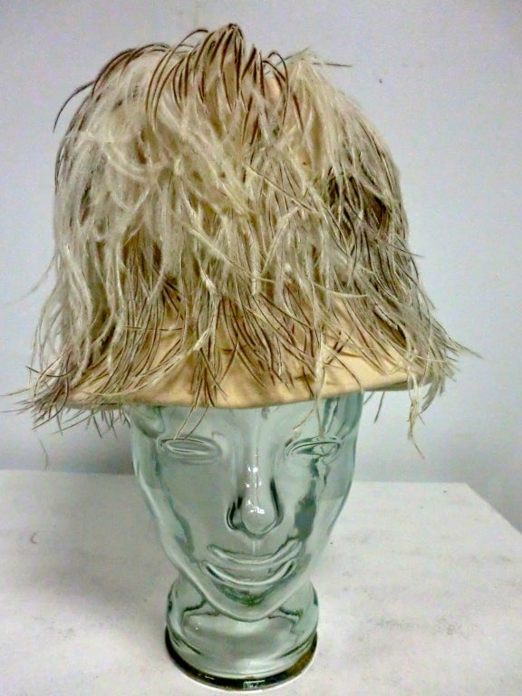 A fantastically dramatic 50s ostrich feather trimmed felt hat in cream and natural feathers by Bern-Allen.  A stingy brim and towering crown trimmed with extravagant feathers!