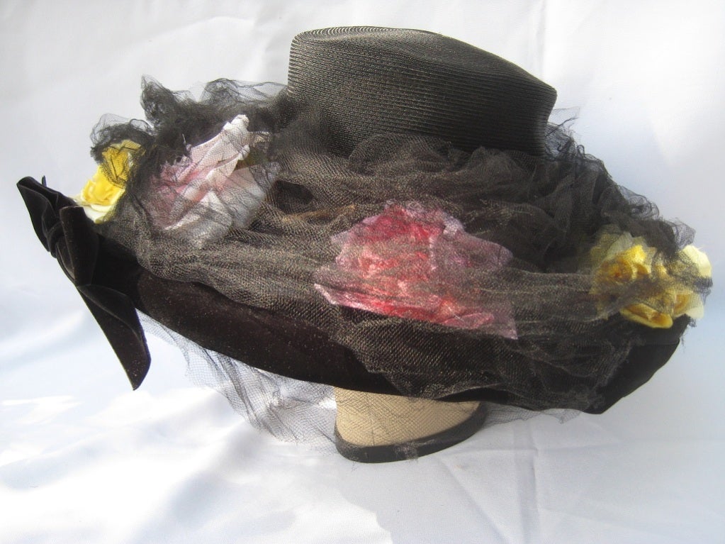 Wonderfully sculpted full hat with black velvet ribbon trimmed brim, arranged with pastel silk roses encased in black fine silk tulle...stunning in its presentation!  Brim measures almost 18