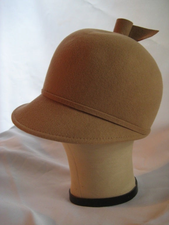 This whimsical, mod hat is made of fine wool felt in camel. Great silhouette and sporty with a great twist detail.