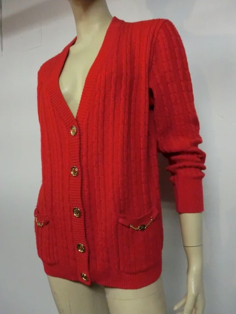 A fabulous 1970s Celine vivid red cable knit lambswool cardigan sweater w/ gold logo buttons and pocket hardware.  Size 44.