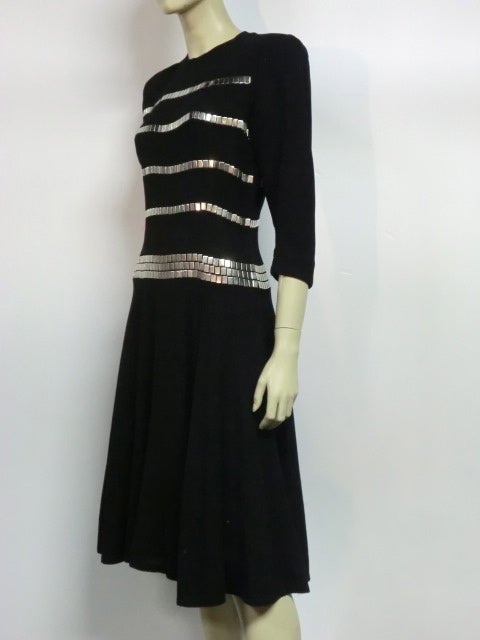 A fabulous 1940s fit and flare wool dress, black with rows and rows of rectangular silver flat studs--heavy at the peplum for weight. Size 4-6.