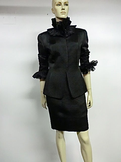 Givenchy 90s wide ribbed faille skirt suit in black silk with heavy organza ruffles at wrist and neck.  Hook and eye closure on jacket.   Marked size 38.