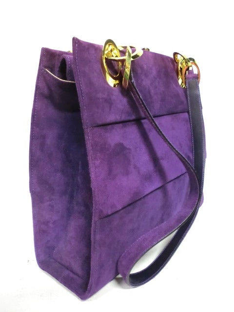 A fantastic medium sized purple suede Salvatore Ferragamo shoulder bag with pleated suede exterior and gold leather interior.  Closure is a magnetic snap at top interior flap. Two shoulder straps, interior key chain holder.  Comes with original dust