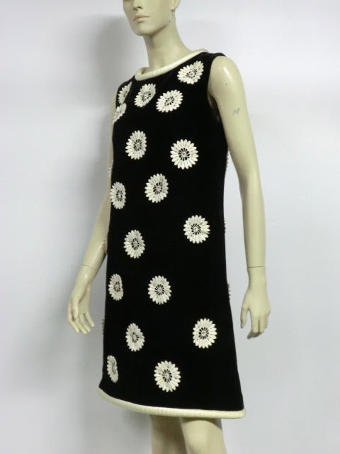 A perky 60s A-line dress in black velvet by Joseph Magnin with white lace daisies and silver rhinestone embellishment.  Neck and hem are piped in padded satin with a bit of wear to the neckline.  Super cute!