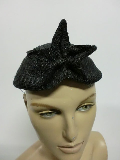 An amazing Hubert de Givenchy 50s hat with a 3-dimensional star design front and center in black finely woven straw.  Succinct straw cap design with incredible star.