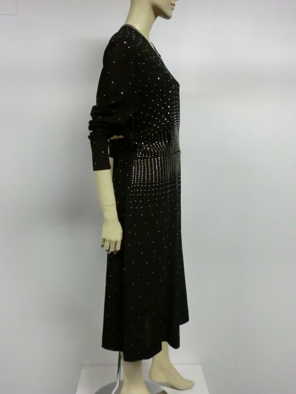 A gorgeous 40s crepe dress in black, heavily studded with silver nail head studs, arranged to emphasize the waist in a great larger size!  Zipper at back of neck and side.  Size 8-12