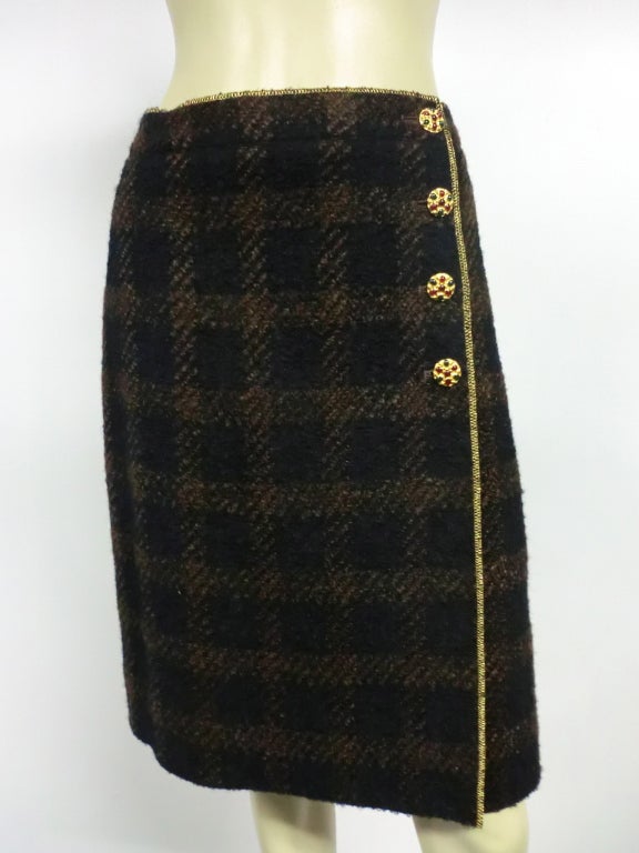 A beautiful Lagerfeld designed Chanel brown/black wool tweed plaid pencil skirt that wraps and buttons in front with embellished gold buttons.  Front flap is faced with gold matelassé.  Fall 1996 collection. Marked size 42.
