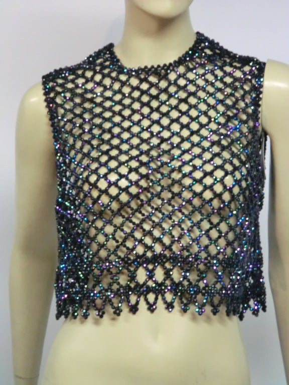 A great little mod 60s accessory!  A cropped-waist, zip-up-the-back, plastic aurora borealis beaded mesh top to add a little dark sparkle to your ensemble.
