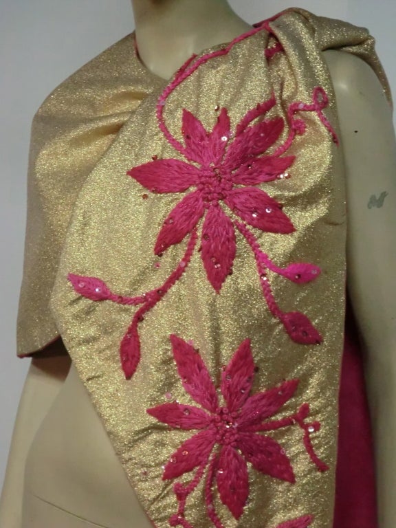 A glam gold lame 50s side-tying stole/wrap with fuchsia silk lining and yarn embroidery scattered with sequins.  One shoulder is fitted and sculpted and the other is for the tie.