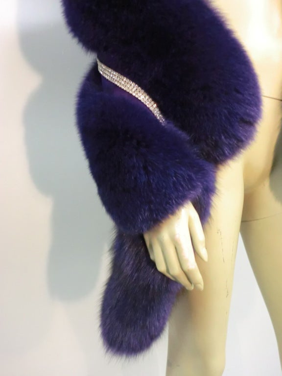 A fabulous, over-the-top, purple dyed wide fox fur boa with tails at each end and a stripe of rhinestone trim running the length.