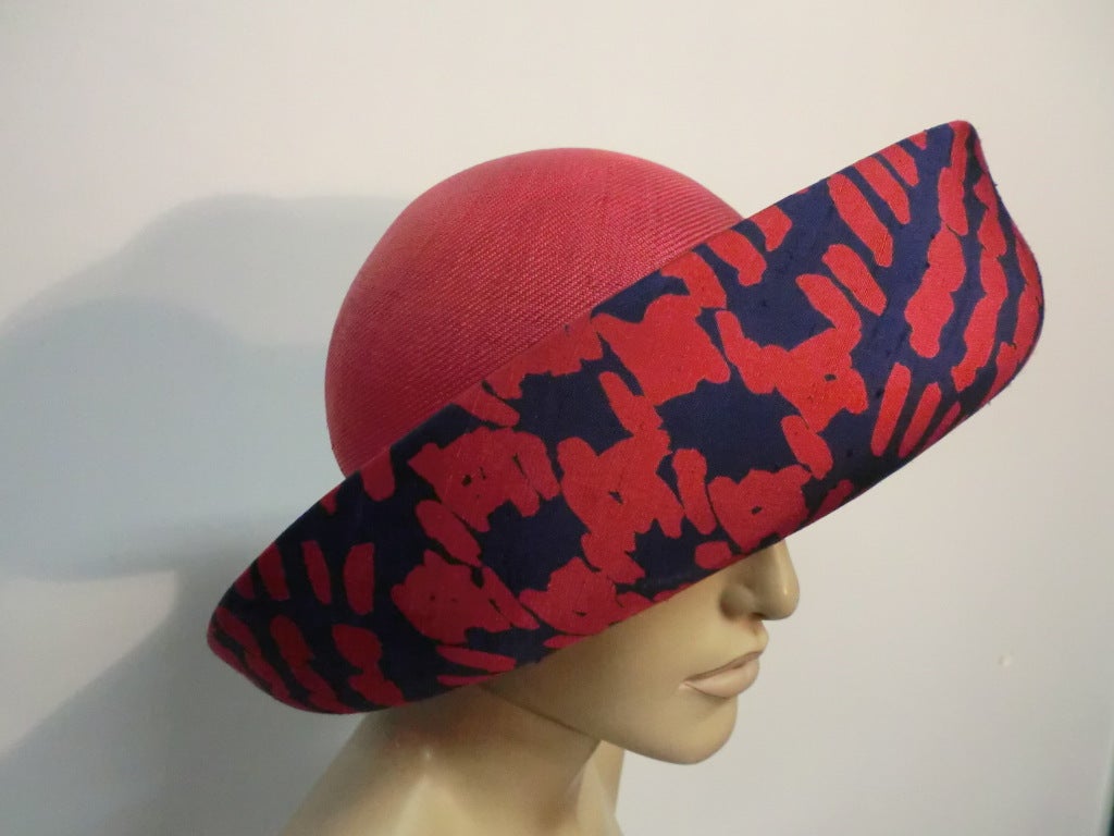 A wonderful 60s Pauline Trigere red straw hat with a large upturned brim, covered underneath with red and indigo patterned silk.  Originally from Marshall Fields.  Size M