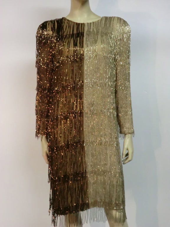 A gorgeous late 70s Bill Blass two-tone (bronze and silvery taupe) bead fringe tunic dress with long sleeves and buttons up the back.  Fully lined with shoulder pads