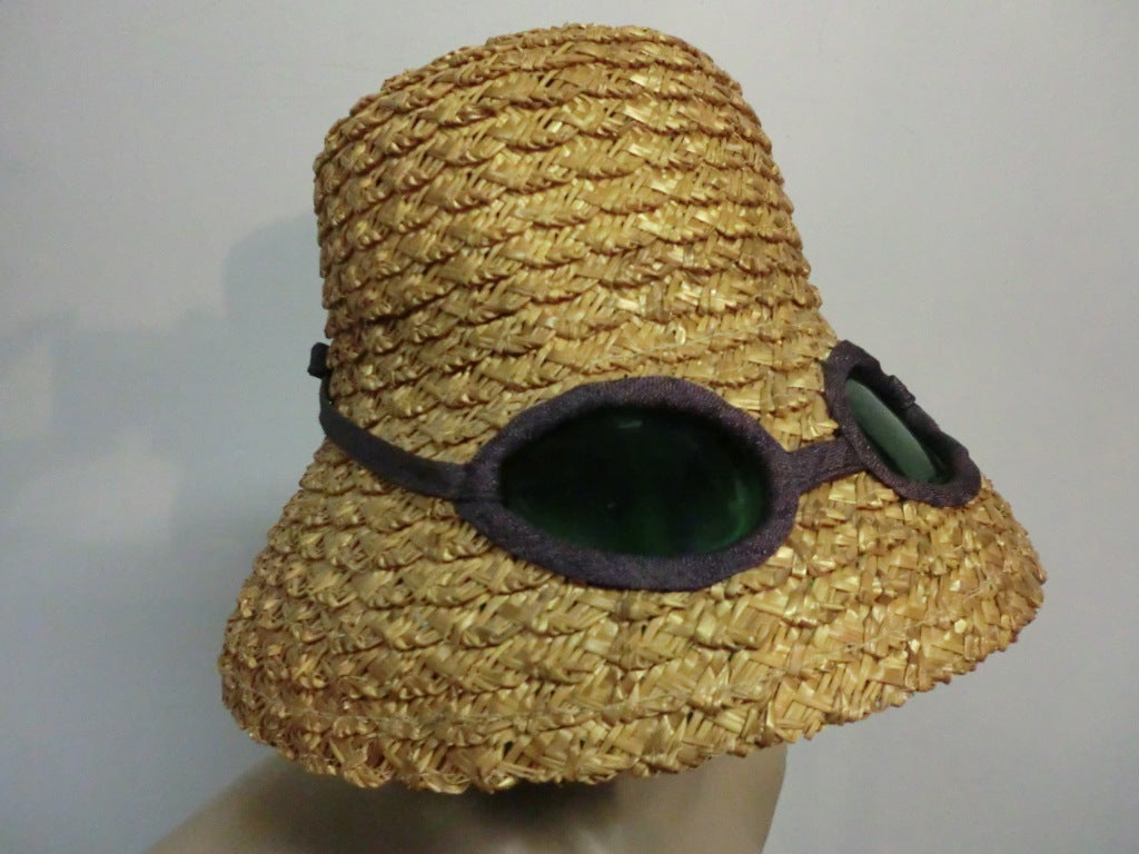 A fantastic whimsical novelty straw hat from the 1950s from Joyce.  Flowerpot shaped straw with inset trompe l'oeil sunglasses.