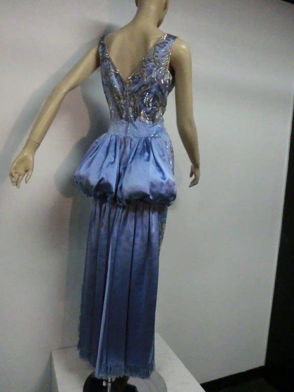 A gorgeous 1950s Christian Dior elaborately beaded and sequined ice blue silk satin fitted column gown with bustle-back in fringed silk satin.  Beautiful stylized floral beading, prong-set rhinestones with fringed 