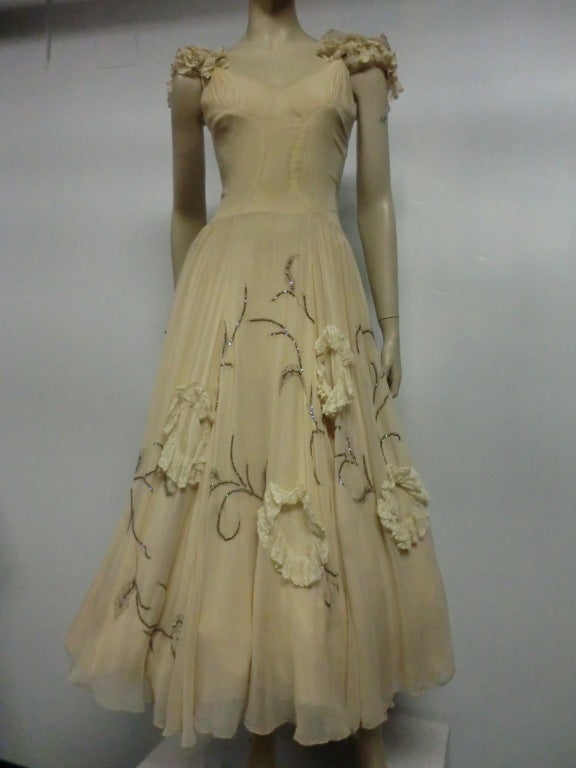 A gorgeous 30s example of Katherine Kuhn's fine couture work in creme silk chiffon, embellished through out the full skirt with the finest beadwork and silk lace applique.  Double layer skirt construction for opaque coverage. Shoulders are prettily