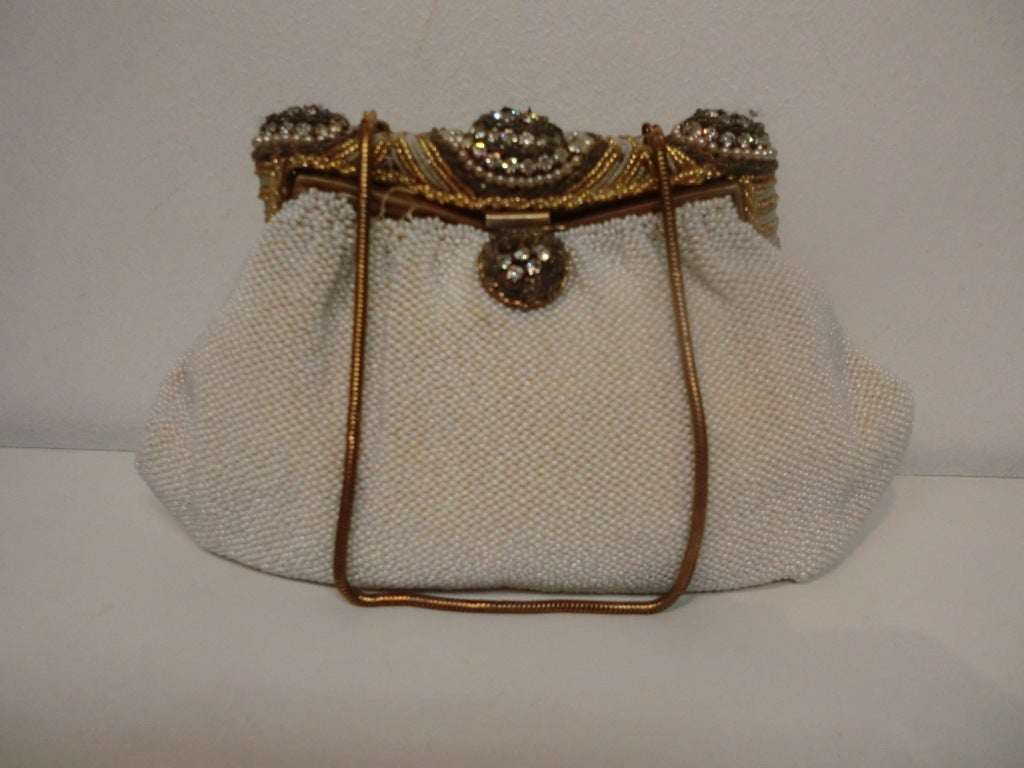 A gorgeous 1940s caviar beaded evening bag in white with incredibly embellished heavy frame.  Satin lined with minor staining.  