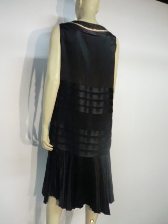 A fantastic 20s black and white piped satin tea dress with low dropped waist pleated skirt and white piped V-Neck