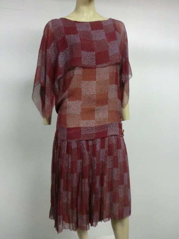 A lovely 1920s tea dress of beautiful geometric print silk chiffon (burgundy and steel gray) with 3 layers of floaty silk chiffon over a neutral liner.  Celluloid buttons at side of dropped waist.  Full pleated skirt.
