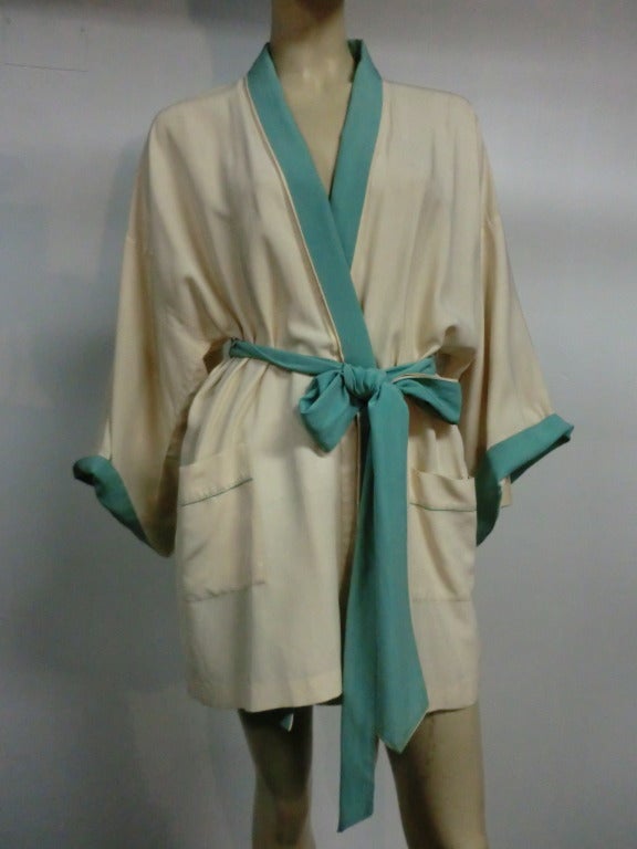 A lovely 1920s silk crepe Asian style, mid-thigh bathrobe in contrasting ivory and mint green.  Front pockets are piped in mint green also.  Cuffed sleeves turn up to reveal green lining