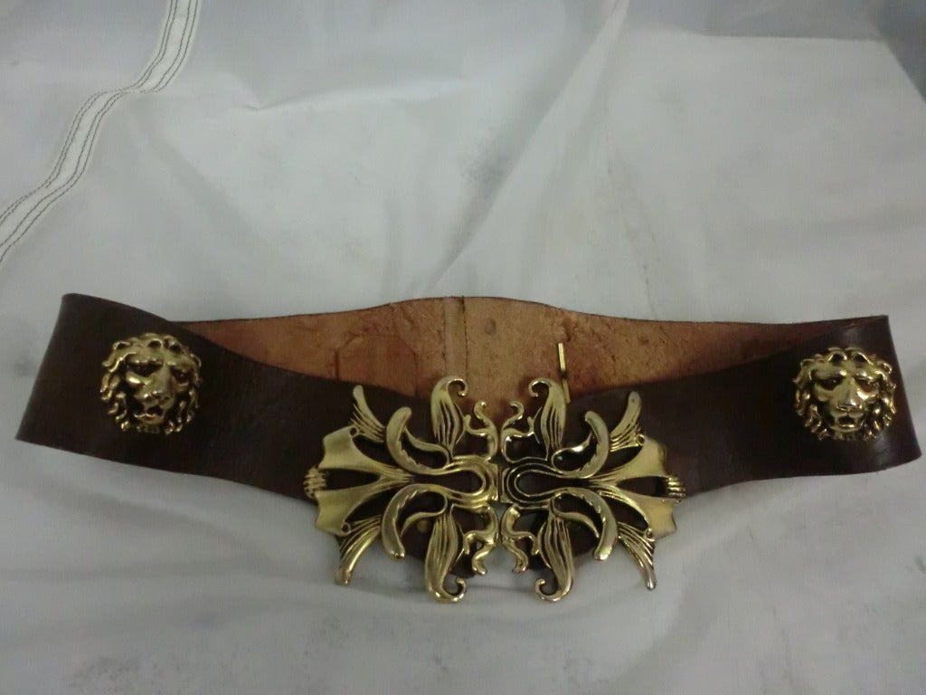 A fabulous brown leather contoured belt with heavy gold-tone buckle and lion's heads studding the length.