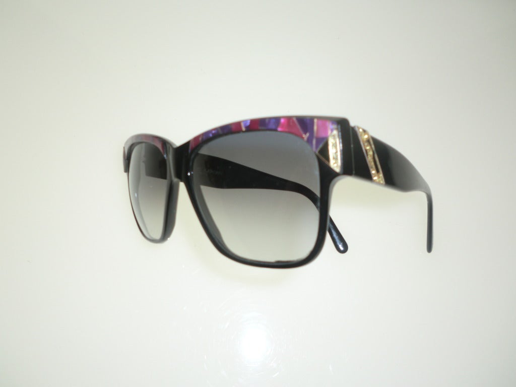 A bold pair of 1970's Charles Jourdan Sunglasses in black resin and faux magenta-hued mother of pearl at temples.  Gray tint to lenses.