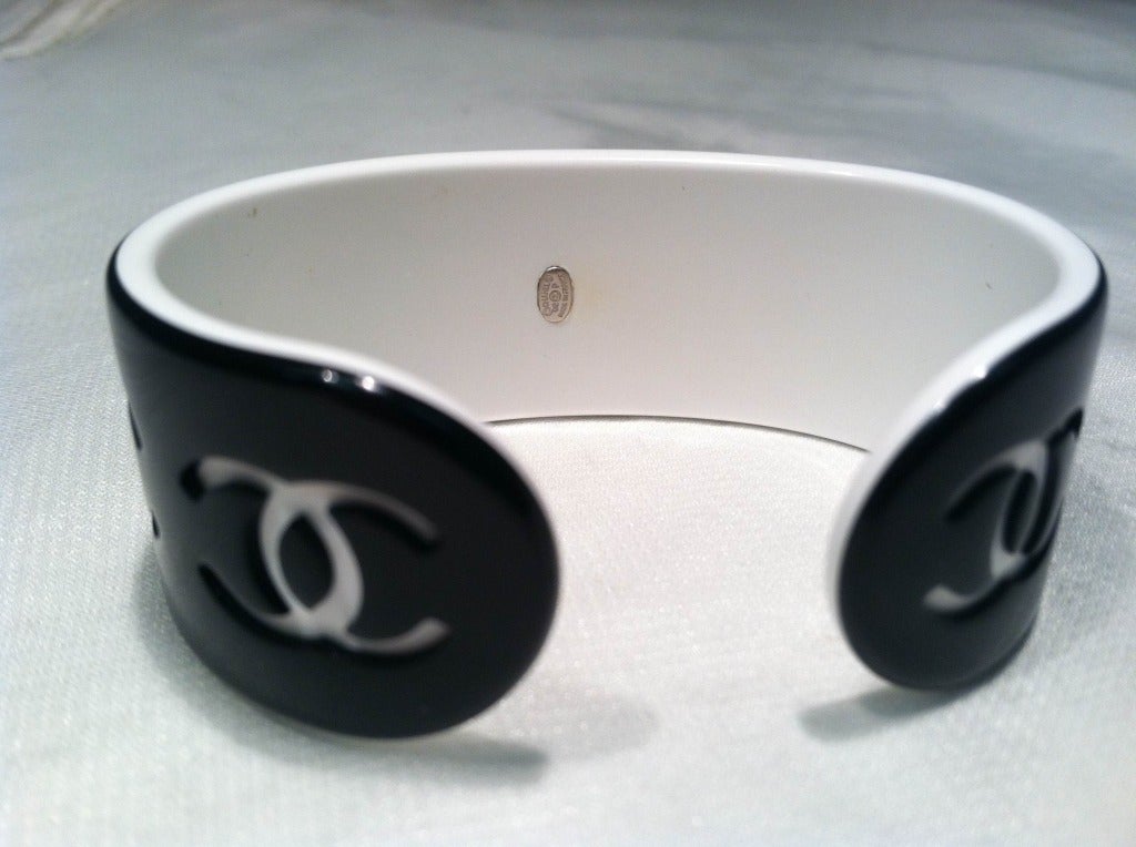 A tiny Chanel incised logo cuff in black and white resin.  Open back.  Marked with silver plaque on the inside.