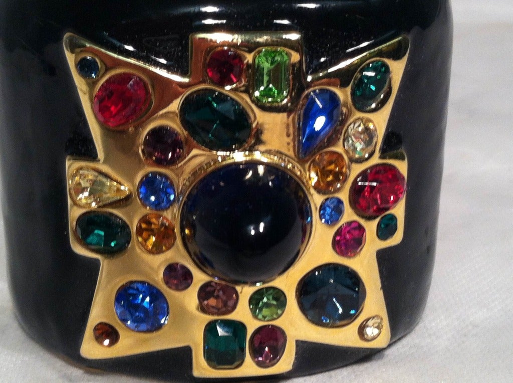 A gorgeous 1980s Kenneth Jay Lane enameled metal cuff bracelet with hinged section and multicolor rhinestone and cabochon glass embellished gold cross.