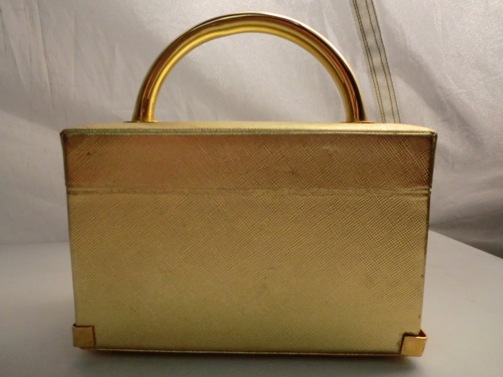 A beautiful 1960s Koret gold textured vinyl box bag with shiny gold-tone hardware and corner guards.  In fantastic condition with tan faille lining and Koret marking