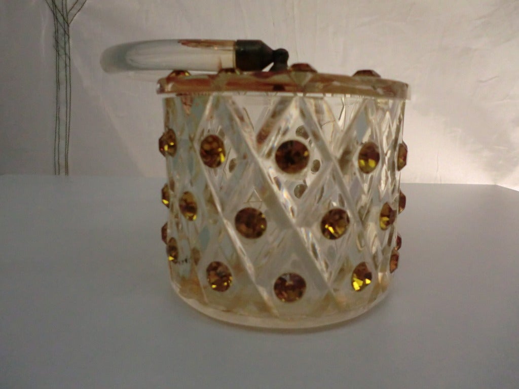 Eine atemberaubende 1950er Jahre Lucite Box Tasche in einer ovalen Form mit geschnitzten Diamanten bedecken die gesamte Oberfläche und mit Topas Farbe große Strasssteine in der gesamten besetzt.  Ein Griff aus klarem Lucit und ein kleiner Verschluss