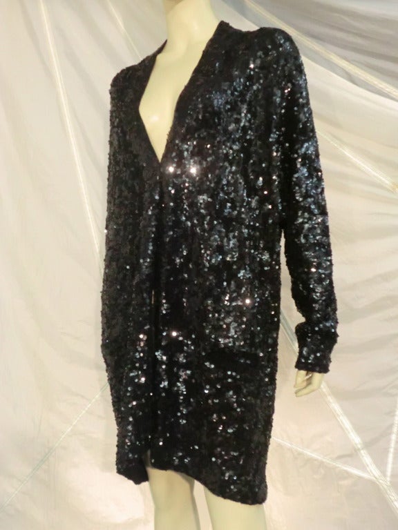 A fabulous Donna Karan knit cardigan:  Oversized with Dolman style sleeves and front closure.  Entirely covered with black sequins.  Open front NO closures.  Small front pockets are still sealed.  Fabulous AND comfortable!
