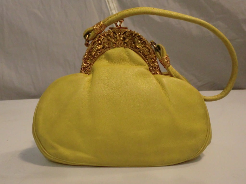 A gorgeous 1970s Rosenfeld lemon-yellow leather evening bag with unusual shape and filigree embellished frame closure.  Lining is in excellent condition and comes with original coin purse.