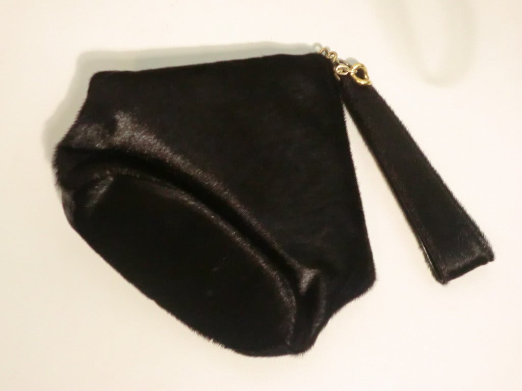 A fabulous 1940s black calf hide handbag in EXCELLENT condition, lined in suede:  Two piped pockets inside and a snap closure.  Unique folding metal slide ring closure  and loop strap.  Roomy enough for a cell phone keys and a small wallet. 