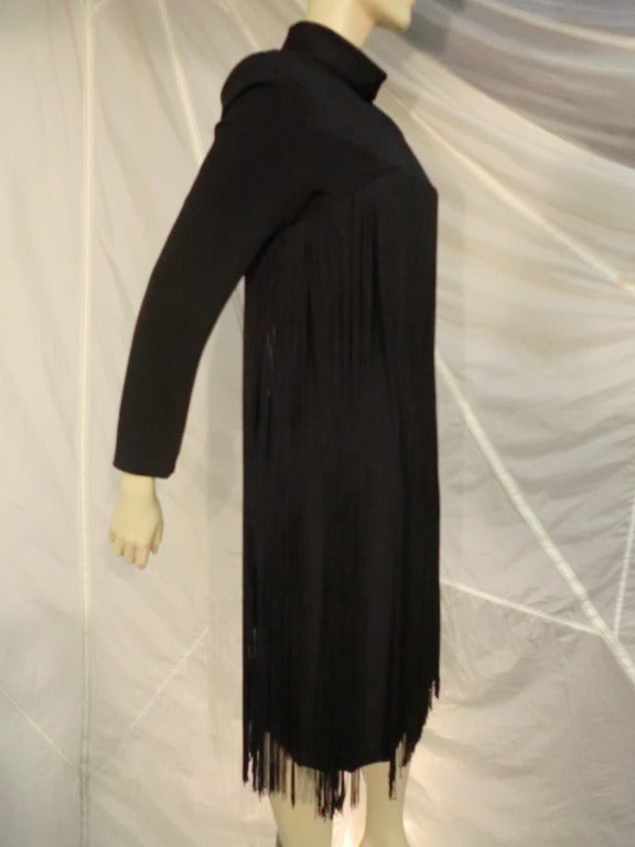 A fun, fringed 1970s Travilla black crepe cocktail dress with mock turtleneck, long sleeves, structured shoulders with pads and long free-flowing rayon fringe from bust to hem.