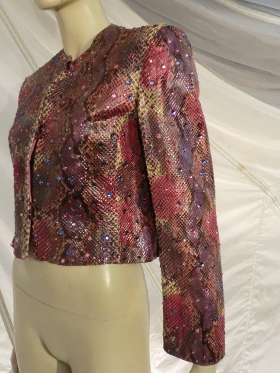 This is a standout 1980s Bill Blass snakeskin jacket:  collarless with button closures, handpainted in pinks, purples and mauve and encrusted with scattered corresponding color rhinestones.  Fully lined with resin buttons.