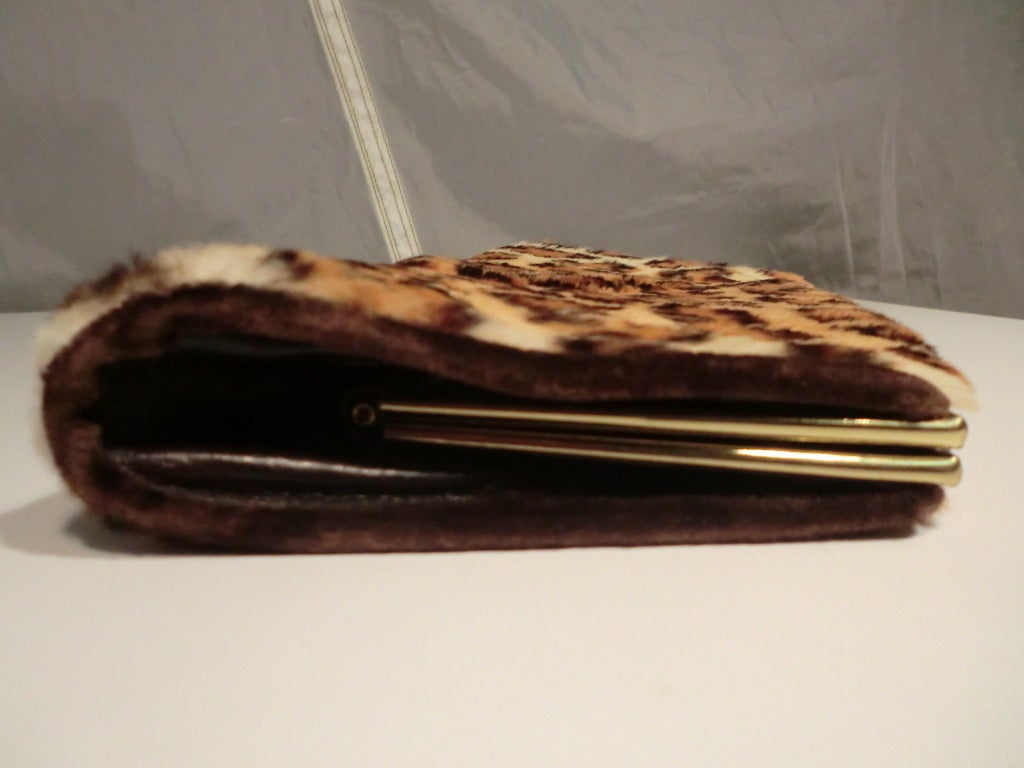 A smart little 1950s leopard stenciled rabbit fur clutch with gold tone frame and brown satin interior. Latch is strong.
