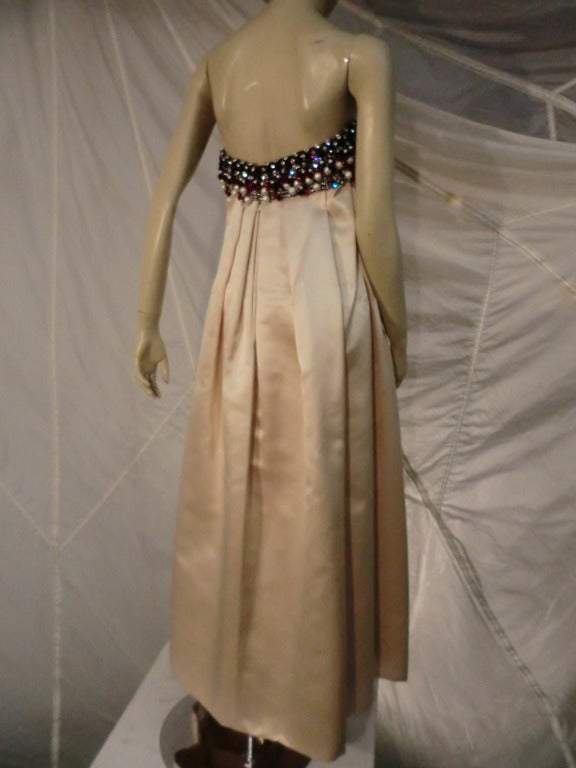 A gorgeous 1968 George Halley Couture gown:  Heavily pleated oyster silk satin skirt and heavily beaded and jeweled (plastic beads and rhinestones) bandeau bodice.  Structured and lined.