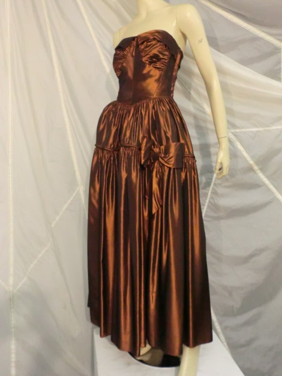A gorgeous 1940s Fred Perlberg brown/black iridescent taffeta strapless ball gown with gathered bust and skirt, piping and bow accents.  Zip closure.