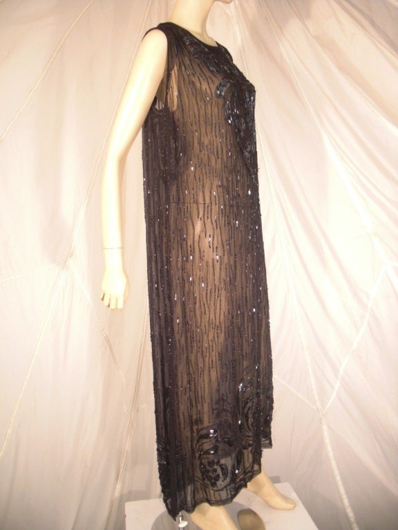 A beautiful black on black beaded chiffon evening dress.  A larger size, this piece could easily be gathered at the dropped hip and made fashionably smaller.  Gorgeous beading pattern.