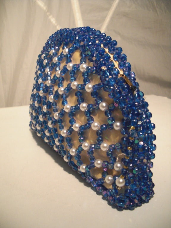 A fabulous 1960s Koret hand beaded evening clutch with blue plastic beads and faux pearls.  Peach color satin lining and original matching coin purse. Zippered at top.
