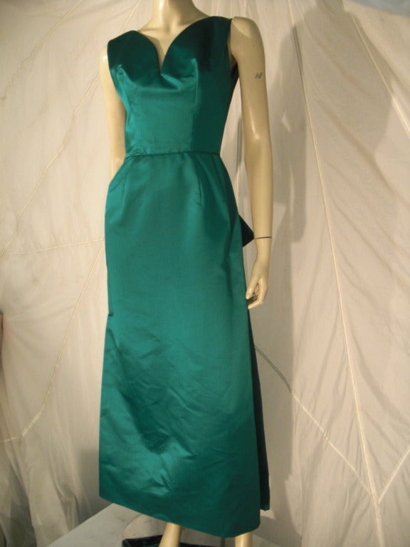 A beautiful 1950s Helga emerald green silk satin gown:  Structured with heavy pleating and bow at back and fitted waist.  Sleeveless with very fitted bust.  Completely lined.  Back zipper