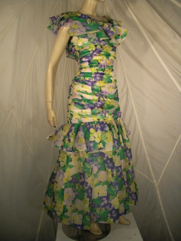 A fabulous 1980s Arnold Scaasi ruched silk chiffon garden party formal gown!.  Ruffles at the neck and flared skirt.  Completely lined.  A gorgeous floral print in purple, green, yellow and white.