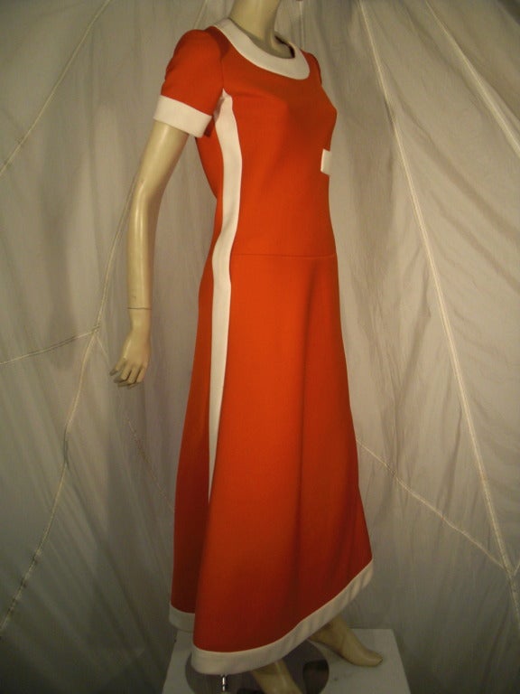 A fantastic 1960s unmarked Nina Ricci maxi dress: Heavy tomato red 4ply knit fabric with inset white accents. Fully lined and exquisitely tailored.  The stripe running down the side becomes two belt loops at the hip.