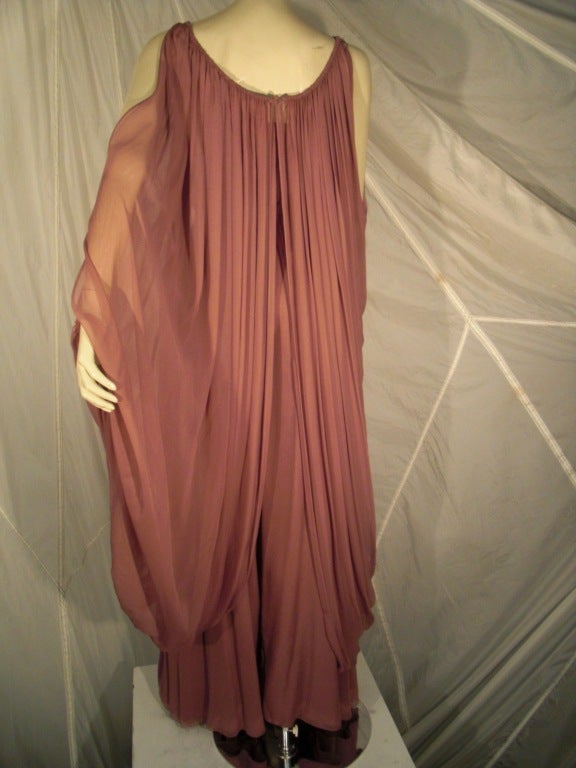 1970s James Galanos 2-piece mauve silk chiffon ensemble:  underpiece is a strapless flared-leg jumpsuit with elasticized top and waistline, made up of 4 layers of hand-rolled (1/8 inch) hems.  Tunic piece (one layer of silk chiffon) buttons at front